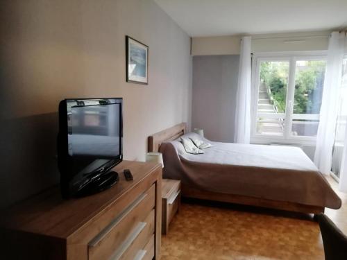 une chambre avec un lit et une télévision à écran plat dans l'établissement Résidence Le Chateau Durieux 3 - Agréable et spacieux logement pour 2 personnes ! MAE-7404, à Aix-les-Bains