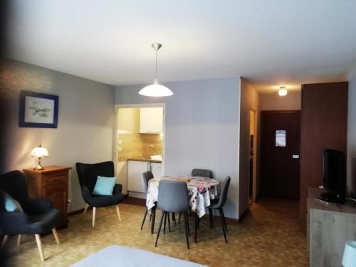 un salon avec une table et des chaises et une cuisine dans l'établissement Résidence Le Chateau Durieux 3 - Agréable et spacieux logement pour 2 personnes ! MAE-7404, à Aix-les-Bains