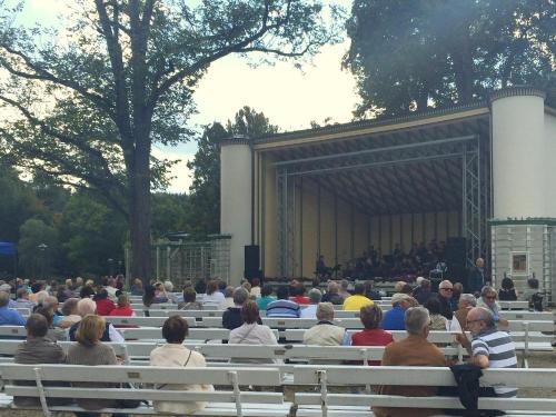 a group of people sitting on benches in front of a stage at Sonnenhof in Bad Elster