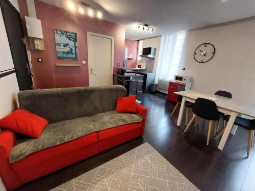 un salon avec un canapé rouge et une table dans l'établissement Résidence Le Juturna - Agréable très fonctionnel et très central ! MAE-7844, à Aix-les-Bains