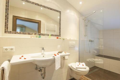 uma casa de banho com um lavatório, um WC e um espelho. em Kaiser-Franz em Bad Hofgastein