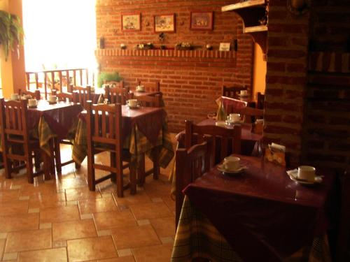 un restaurante con mesas y sillas y pared de ladrillo en la Hostería del Sur de Villa Gesell