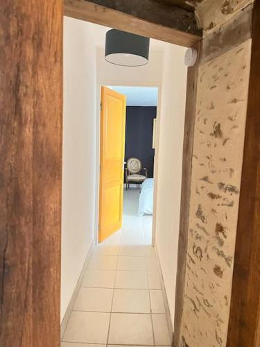 a hallway with a yellow door in a room at Maison des Chevilles in La Châtre