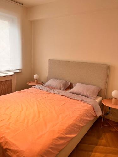 ein Schlafzimmer mit einem großen Bett mit zwei Tischen in der Unterkunft Ostendeau - stijlvol appartement in hartje Oostende in Ostende
