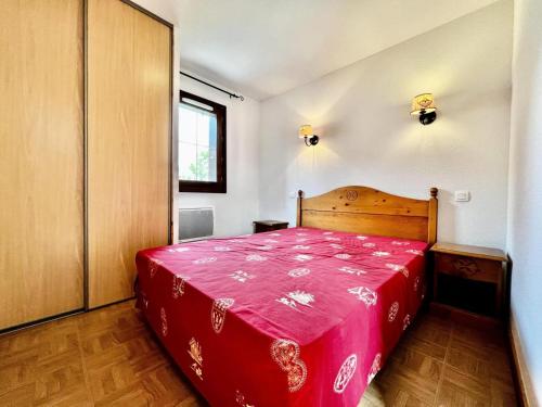 sypialnia z czerwonym łóżkiem w pokoju w obiekcie Les Chalets Des Evettes - Agréable appartement au pied des pistes MAE-1724 w mieście Notre-Dame-de-Bellecombe