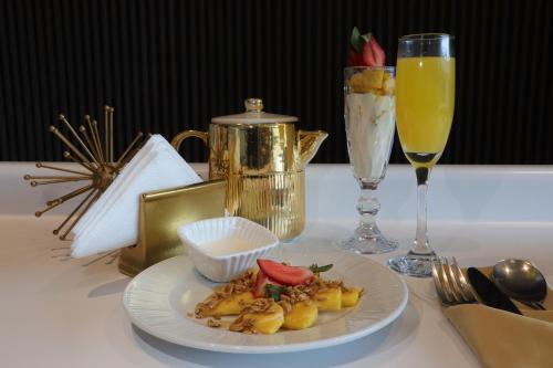 a table with a plate of food and a glass of wine at Grand Hotel&Casino Vía Dorada in Pachuca de Soto