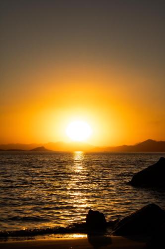 a sunset over the ocean with the sun setting at Pousada Bela Vista in Ilha do Mel