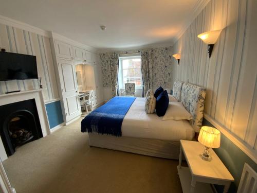 a bedroom with a bed and a fireplace and a television at The Casterbridge in Dorchester
