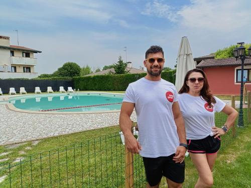 a man and a woman standing next to a fence at Hotel Residence - Il Giardino del Cigno in Latisana