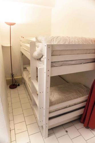 Ce lit se trouve dans un dortoir doté de 2 lits superposés blancs et d'une lampe. dans l'établissement Villegiales Tee2 - En Rez de jardin dans une résidence avec piscine MAE-1154, à La Grande Motte