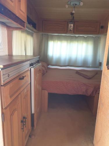 a small bedroom in an rv with a bed at Aquariumi Jale Camping in Jal