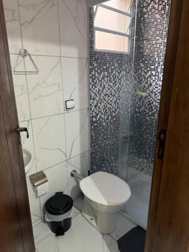 ein Badezimmer mit Toilette und Glasdusche in der Unterkunft Casa Aconchego 6min basílica in Aparecida
