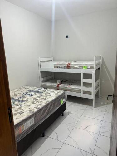 ein Schlafzimmer mit zwei Etagenbetten in einem Zimmer in der Unterkunft Casa Aconchego 6min basílica in Aparecida