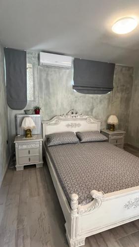 a bedroom with a white bed and two night stands at Eternia Suites in Katakoúli