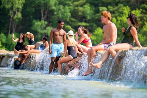 a group of people sitting on rocks in the water at Aloha Beach Resort in Wisconsin Dells