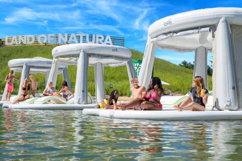 a group of children are sitting on inflatables in the water at Aloha Beach Resort in Wisconsin Dells