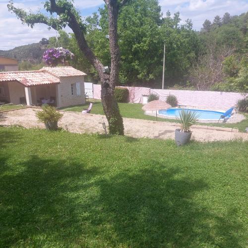 une cour avec un arbre et une piscine dans l'établissement cabanon provencal en pierre, à Riez
