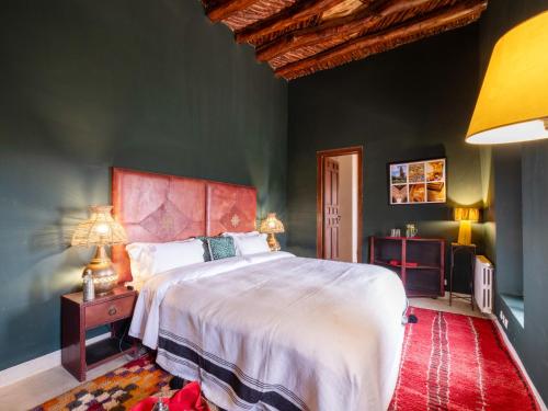 a bedroom with a large bed and green walls at Kasbah Agafay Hotel & Spa in El Karia