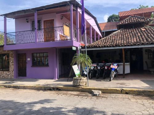 a purple building with motorcycles parked in front of it at The Landing Hotel And Restaurant in Moyogalpa
