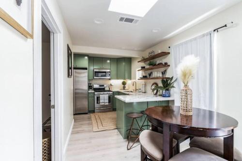a kitchen with green cabinets and a wooden table at Cozy 2 bdrm Home in the Heart of SCV near Six Flags in Santa Clarita