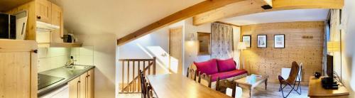 a kitchen with a red couch in a room at Résidence Les Belles Roches - Appartement 6 personnes coeur de village MAE-7994 in Notre-Dame-de-Bellecombe