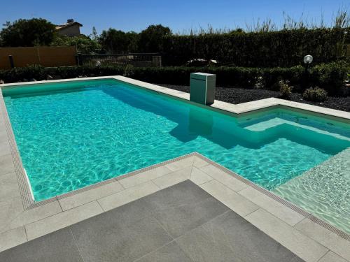 a swimming pool with blue water in a yard at Sun Holidays Home in Marina di Modica