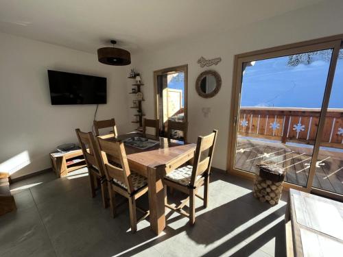 une salle à manger avec une table et des chaises et une fenêtre dans l'établissement Résidence Res Cristal - APPARTEMENT NEUF DE CHARME FRONT DE NEIGE MAE-6384, à Notre-Dame-de-Bellecombe