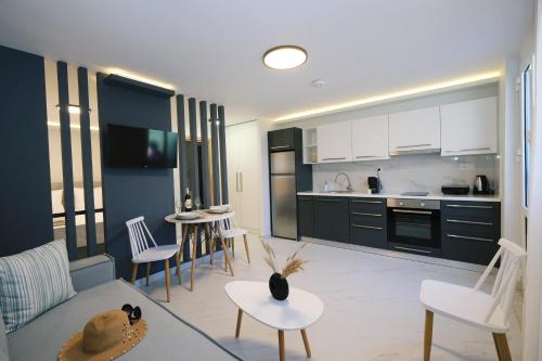 a kitchen and living room with a couch and chairs at Nerea Apartments in Agios Ioannis Kaspaka