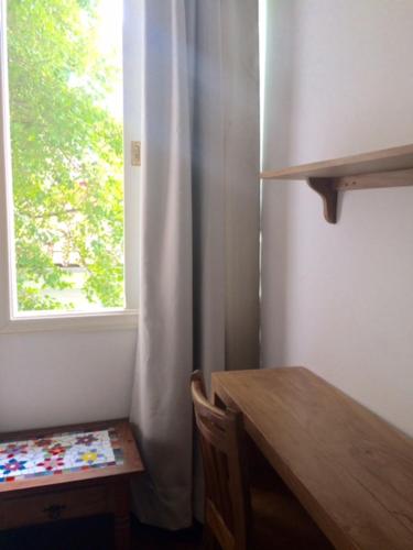 a room with a wooden table and a window at Zen Hotel Brasil in São Paulo