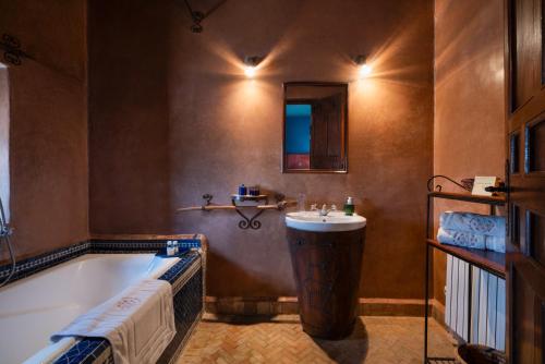 a bathroom with a tub and a sink at Kasbah Agafay Hotel & Spa in El Karia