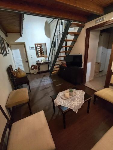 a living room with a table and a staircase at Rodia in Kynopiástai