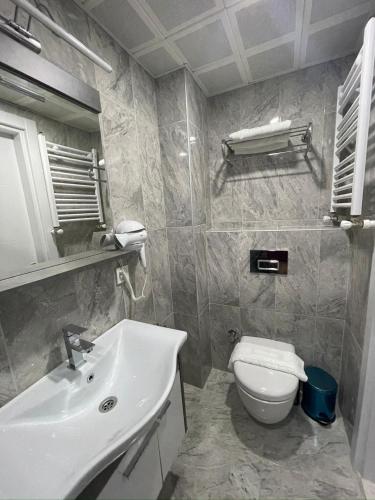 a bathroom with a white sink and a toilet at Fabesco Suite in Istanbul