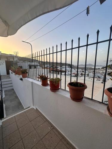 a balcony with potted plants on a fence at Vagelis Apartment&studios lindos in Lindos