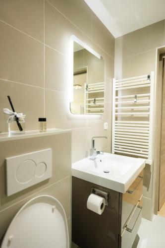 une salle de bain avec des toilettes blanches et un lavabo dans l'établissement Beautiful yellow apartment near Marais and Bastille, à Paris