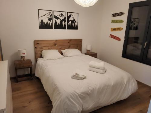 une chambre avec un lit blanc avec deux serviettes dessus dans l'établissement Appartement proche télécabine, à Saint-Gervais-les-Bains