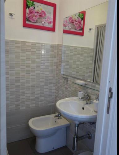 a bathroom with a sink and a toilet and a mirror at B&B Giulia in Taormina