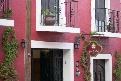 a pink building with a door and a sign on it at Hotel Casa de Vino in Tequisquiapan