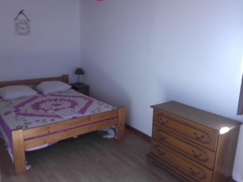 une chambre avec un lit et une commode en bois dans l'établissement Maison avec piscine, à Aubenas