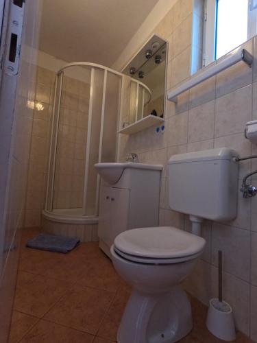 a bathroom with a toilet and a sink and a shower at Apartmani Daniela in Rab