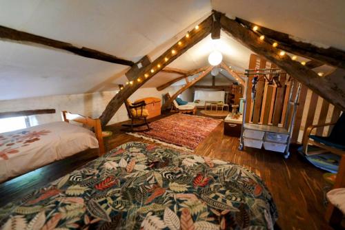 a bedroom with a large bed in a attic at Maison de village in Montcabrier