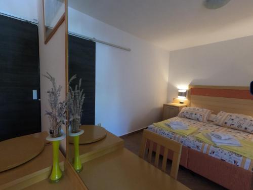 a small bedroom with a bed and a table at Apartmani Daniela in Rab