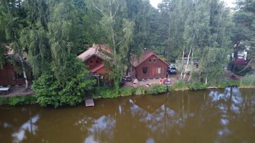 an aerial view of a cabin next to a river at Ośrodek Azyl Mironice in Kłodawa