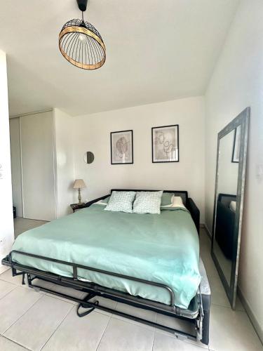 - une chambre avec un grand lit vert dans l'établissement Cosy studio avec parking et vue féerique, à Nice