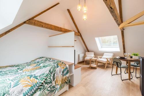 a bedroom with a bed and a table and chairs at Studio Charmant -Cœur de Lannion - Tout equipé in Lannion