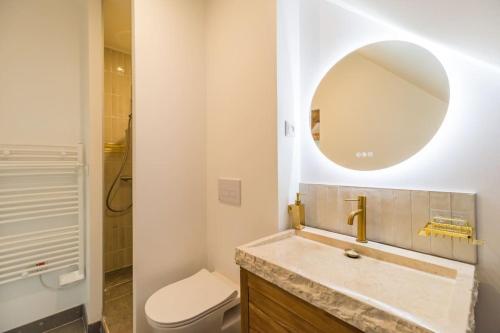 a bathroom with a sink and a toilet and a mirror at Studio Charmant -Cœur de Lannion - Tout equipé in Lannion