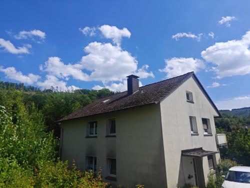 a white house with a chimney on top of it at IaM 3 Zimmer 90 qm Küche Badezimmer kraftraum 44 u in Plettenberg
