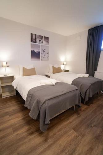 two beds in a hotel room with two lamps at Lägenhetshotell i Sveg in Sveg