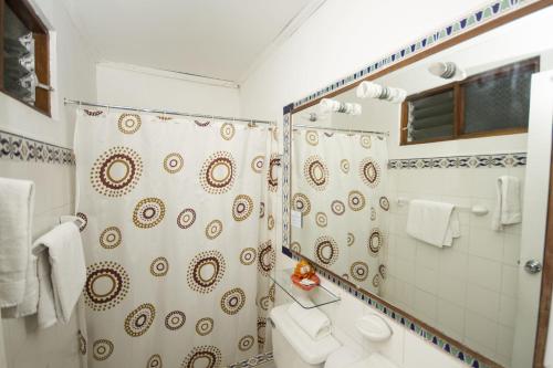 a bathroom with a shower curtain and a toilet at Hotel 1492 in San José