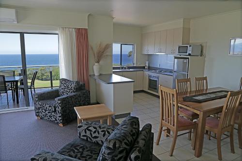 a living room with a kitchen and a dining room at Amooran Oceanside Apartments and Motel in Narooma