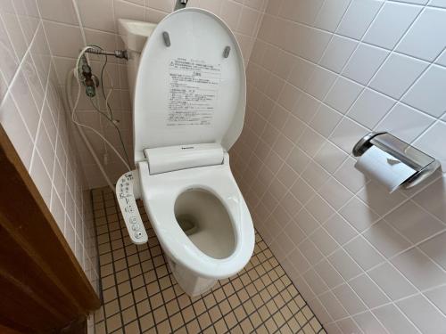 a white toilet in a bathroom with a roll of toilet paper at Agriland E, a village of dreams, wind and music - Vacation STAY 88882v in Ibusuki